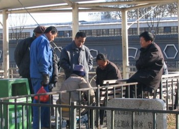 Guys outside playing chinese chess
