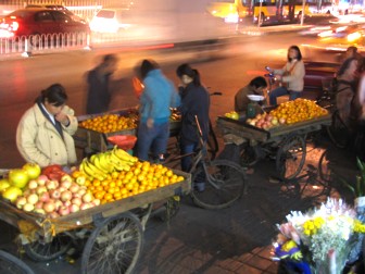 People selling fruit at night in the cold