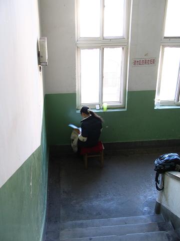 A student is reading English aloud in a hallway.