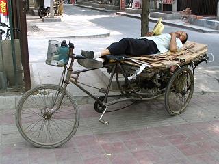 Man sleeping on his bicycle in the shade