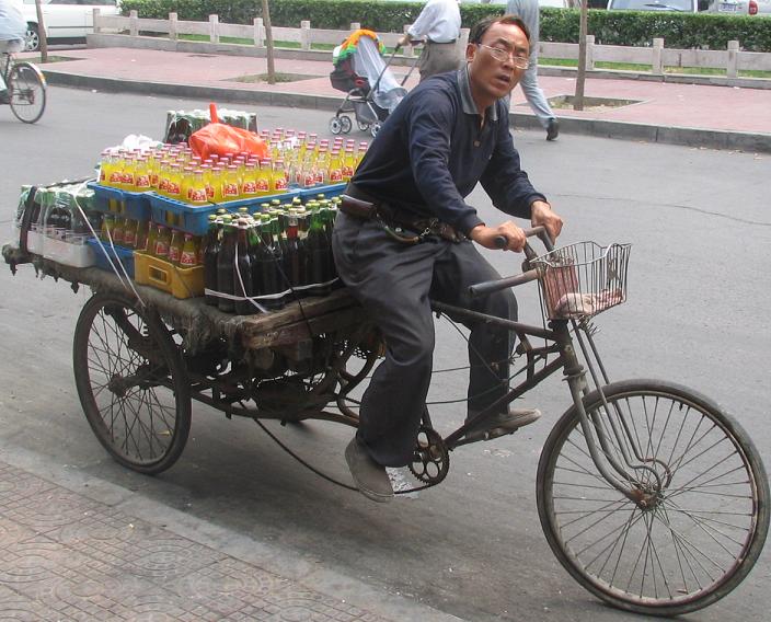 This guy delivers bottles. From what I remember in the states, we used trucks to do this. But getting on and off a bicycle seems a little easier
